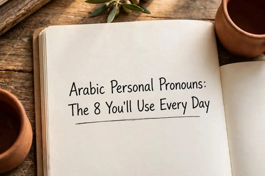 Open notebook on a rustic wooden table with handwritten title: Arabic Personal Pronouns: The 8 You'll Use Every Day